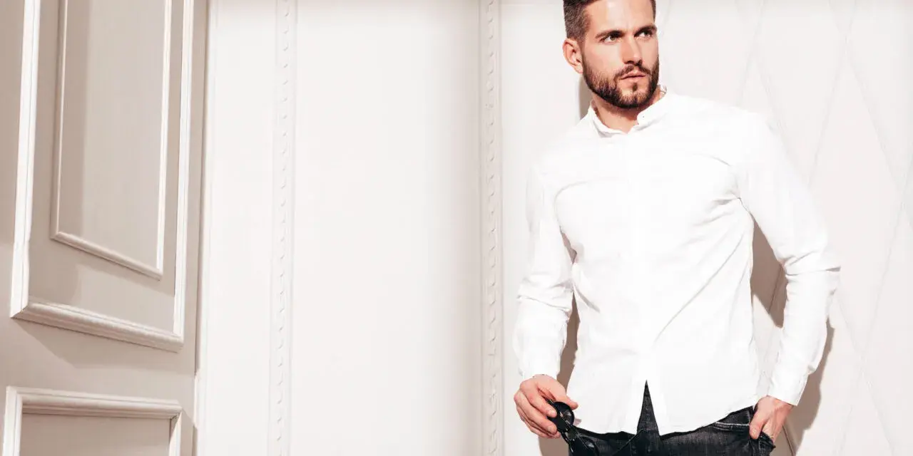 Mężczyzna w białej koszuli i jeansach, prezentujący styl slim fit.